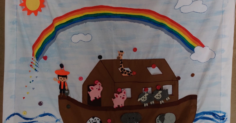Dit wandkleed heeft Annie gemaakt voor het kinderwerk. Elke kinderwerkdag wordt er een stel dieren toegevoegd. Het knoopje in hartvorm is voor de duif...