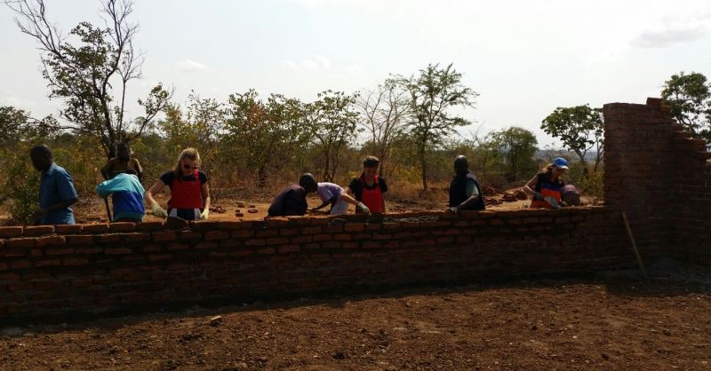 Samenwerking van de groep en Malawianen tijdens de bouw