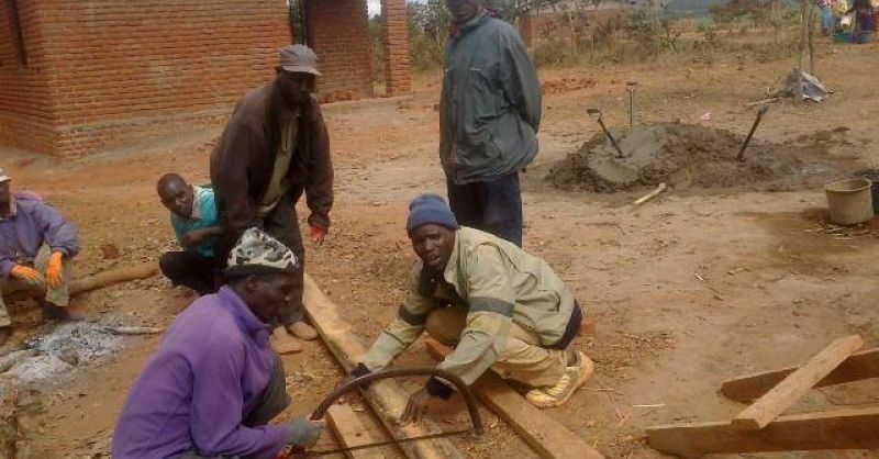 De lokale bouwvakkers zagen hout voor de dakconstructie