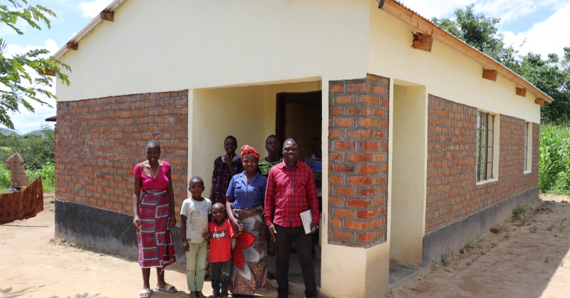 The deputy head teacher nd family infront of the new house