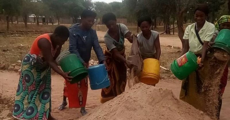 De vrouwen uit Fipungu verzamelen zand
