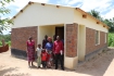 The deputy head teacher nd family infront of the new house