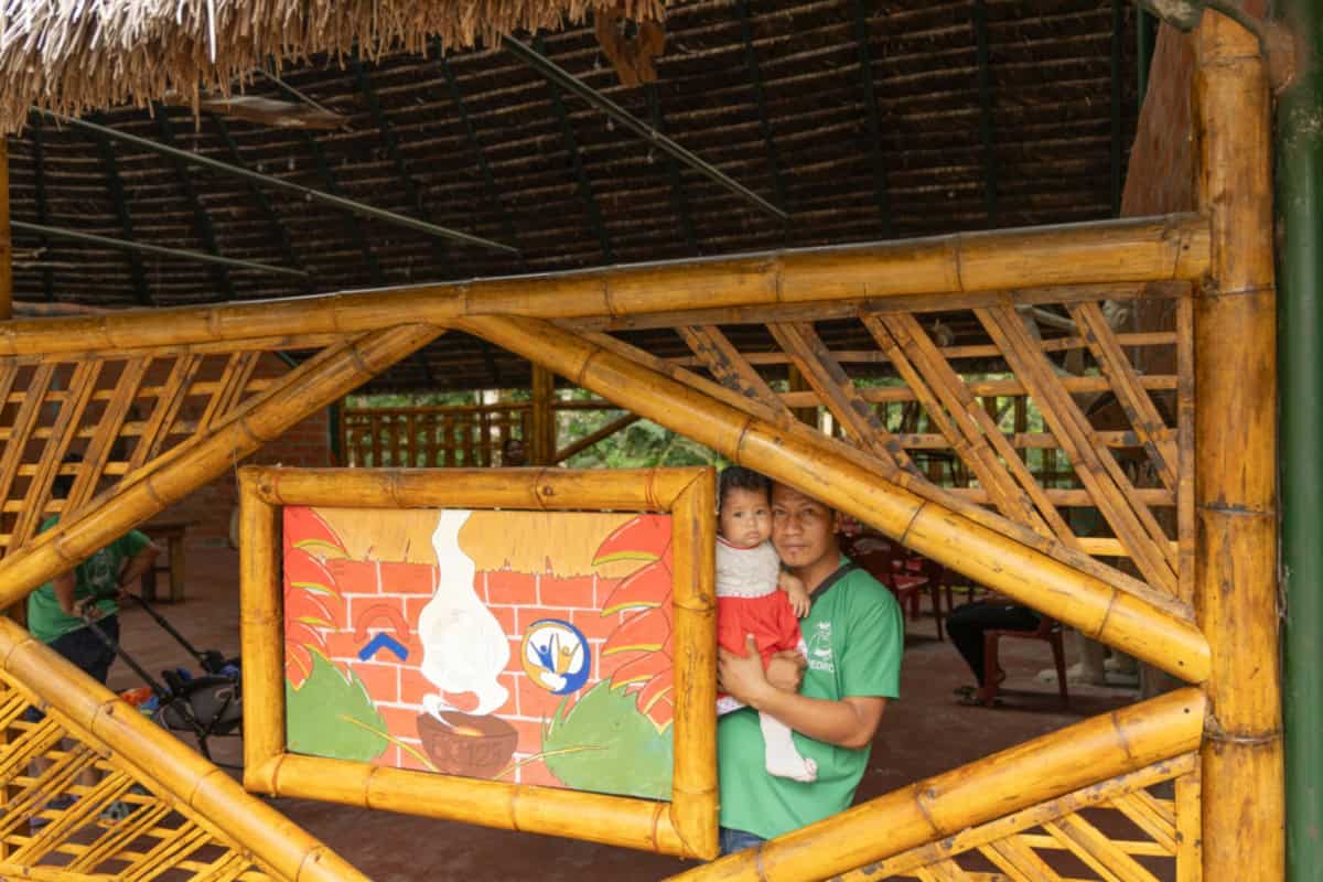 Kind en begeleider in de gemeenschapsruimte van Sinchi Warmi, gebouwd door World Servants.