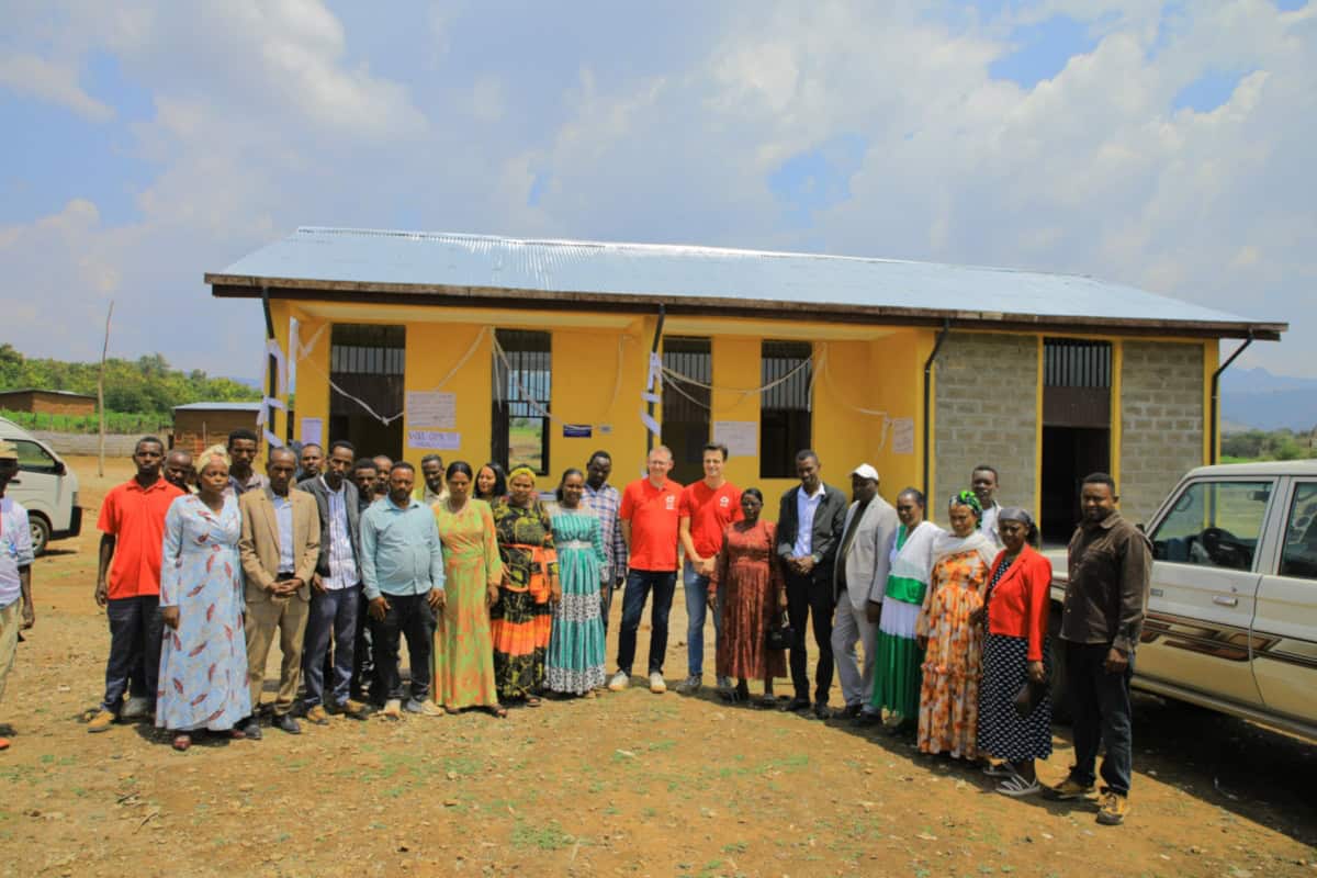Groepsfoto tijdens feest in Bele Town met lokale bewoners en vrijwilligers.