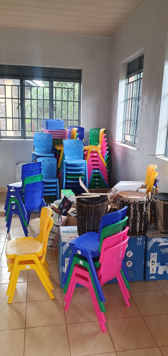 Stapel kleurrijke plastic stoelen voor Nyarusange project.