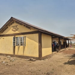 Kwonosor Academy Primary School in Gambia, with children outside in sunny weather.