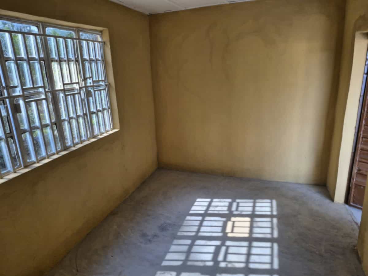 Binnenruimte van een schoolgebouw onder constructie, met zonlicht dat door ramen schijnt.