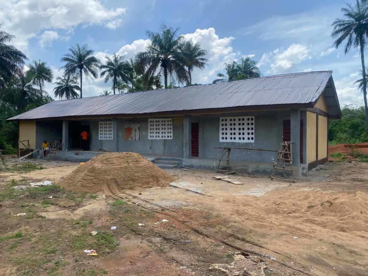 Bouw van een school door World Servants in een ontwikkelingsland, met palmboomachtergrond en heldere.