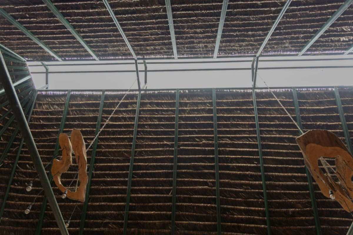 Binnenkant van de gemeenschapsruimte Sinchi Warmi met houten details en metalen structuur.