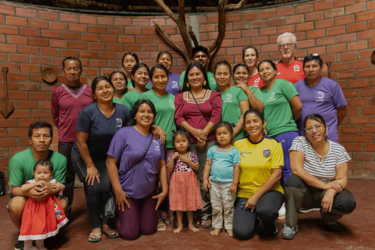 Groep mensen in de gemeenschapsruimte van Sinchi Warmi, vrijwilligers en bewoners.