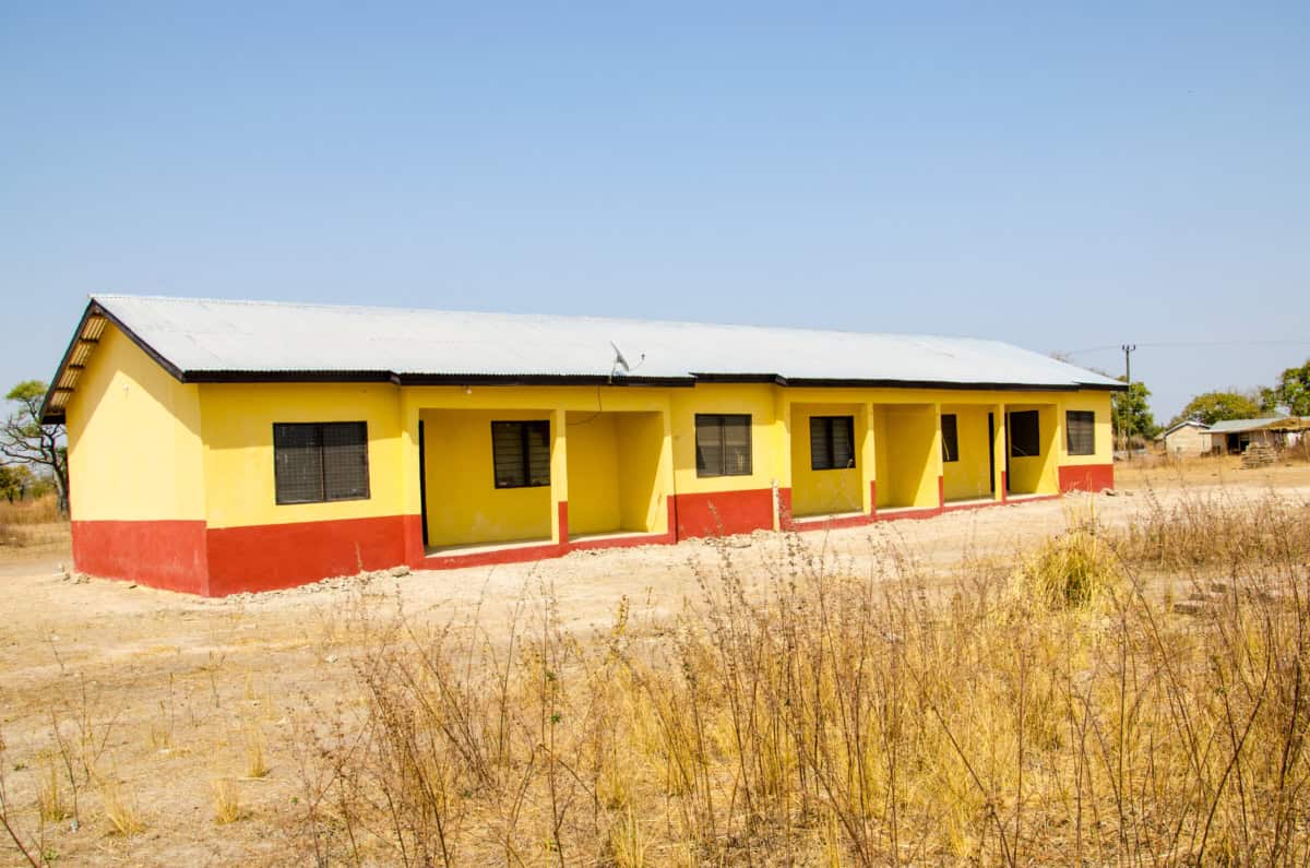 Geel en rood huis in dorre omgeving, gebouwd door World Servants.