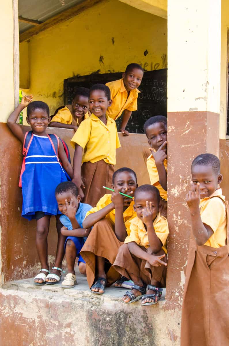Blije kinderen in schooluniform voor schoolgebouw in Kokosiase.