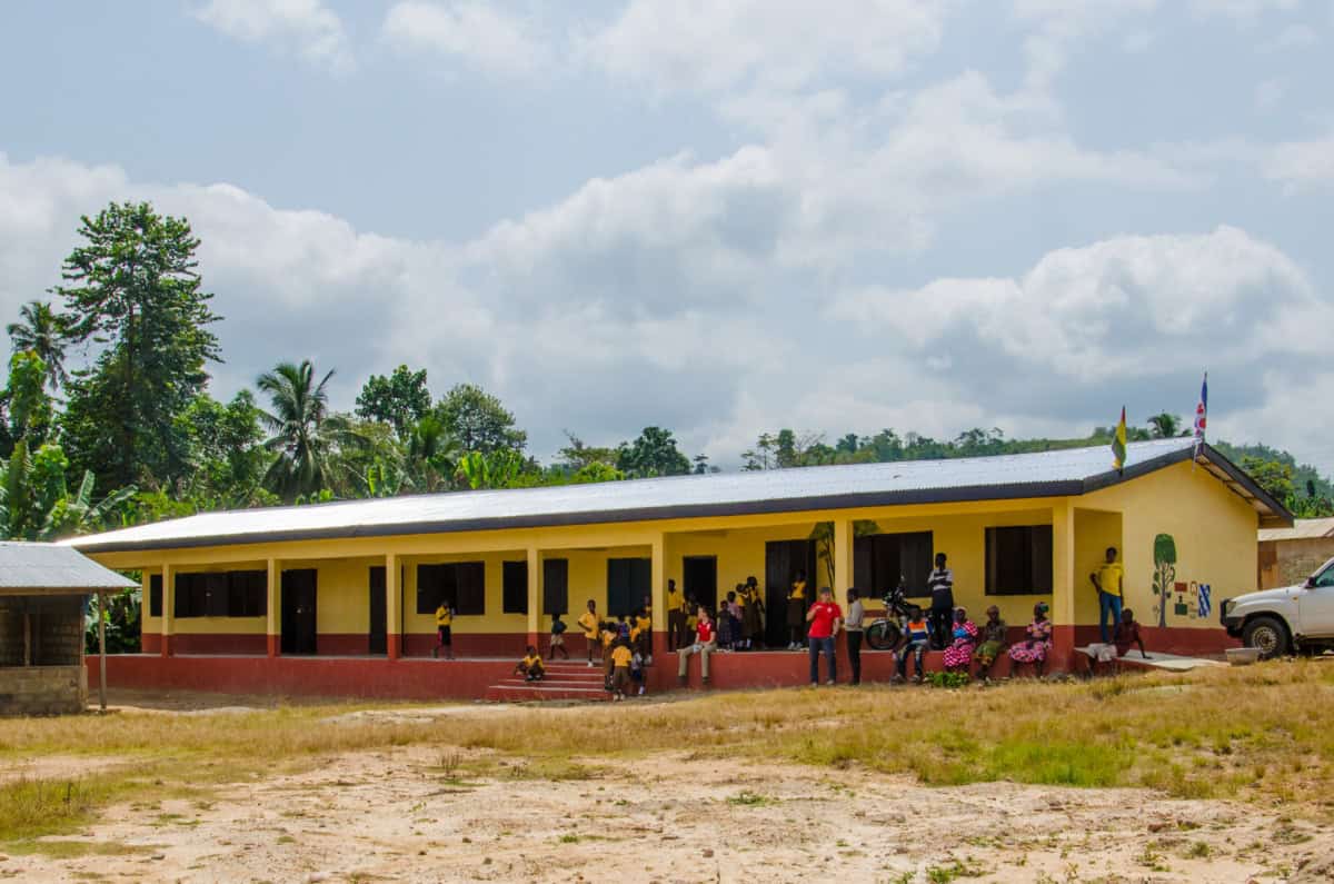Schoolgebouw in Kokosiase met kinderen en vrijwilligers.