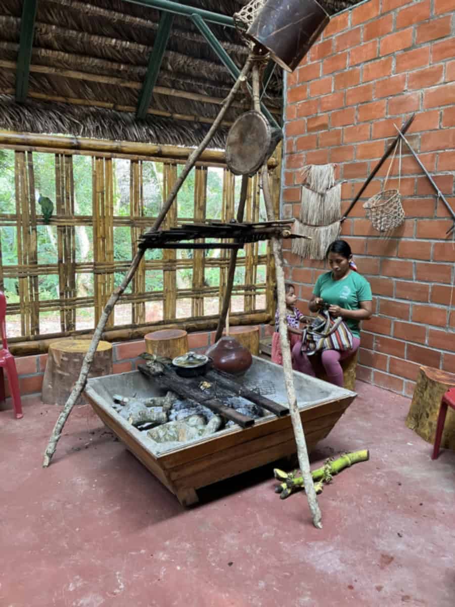 Interieur van de gemeenschapsruimte Sinchi Warmi met traditionele open haard.