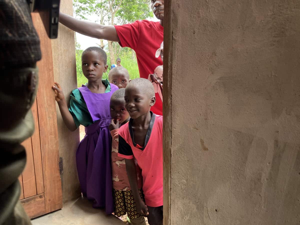Kinderen wachten bij een bouwproject in Kaviwale, ondersteund door World Servants.