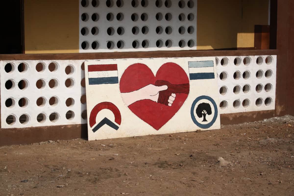 Muurkunst met hart, handen en symbolen voor samenwerking en gemeenschapszin.