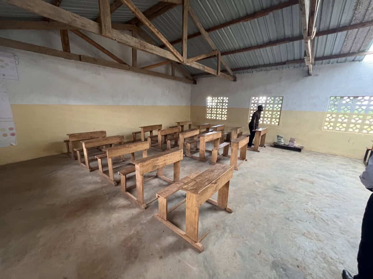 Schoolklas in Mkazimasika met houten banken en stoelen.