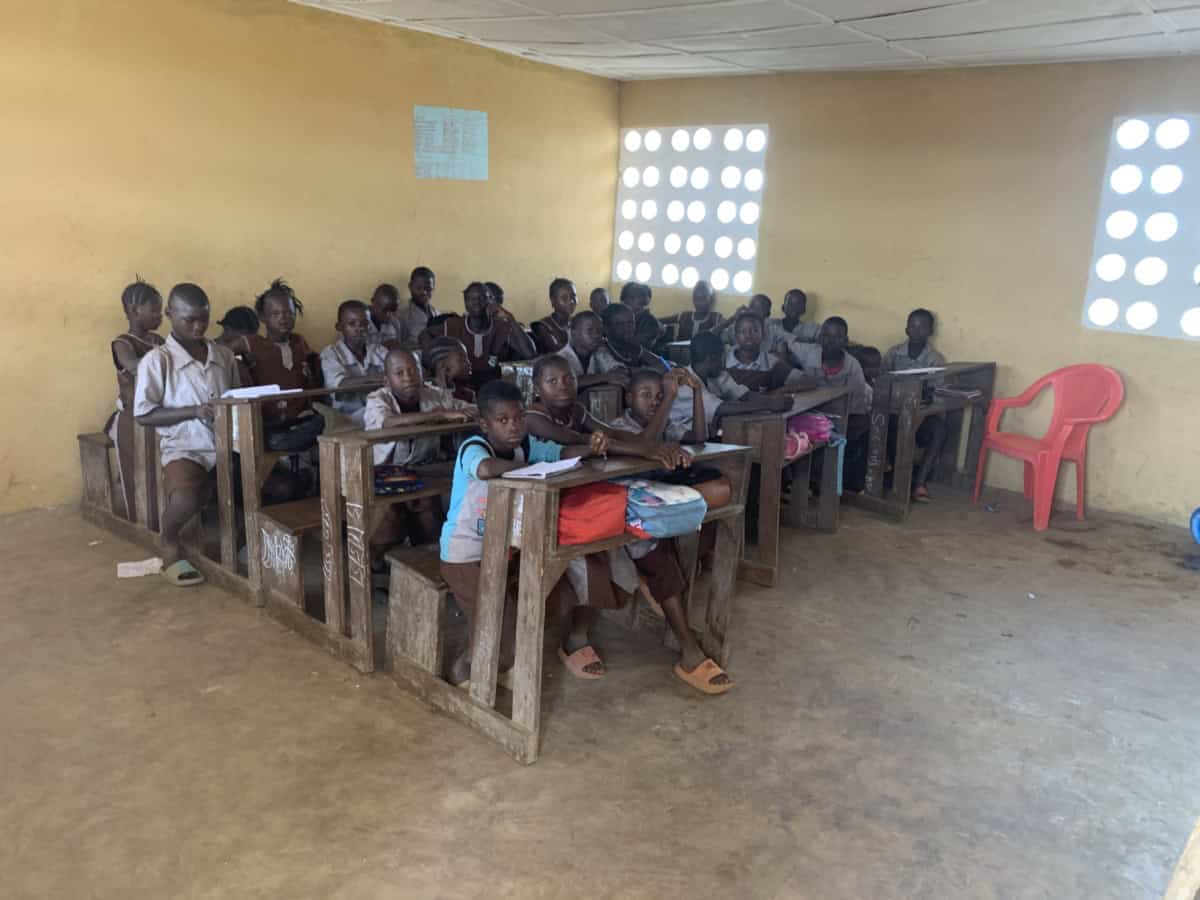 Kinderen leren in een klaslokaal in Guinnee, ondersteund door World Servants.