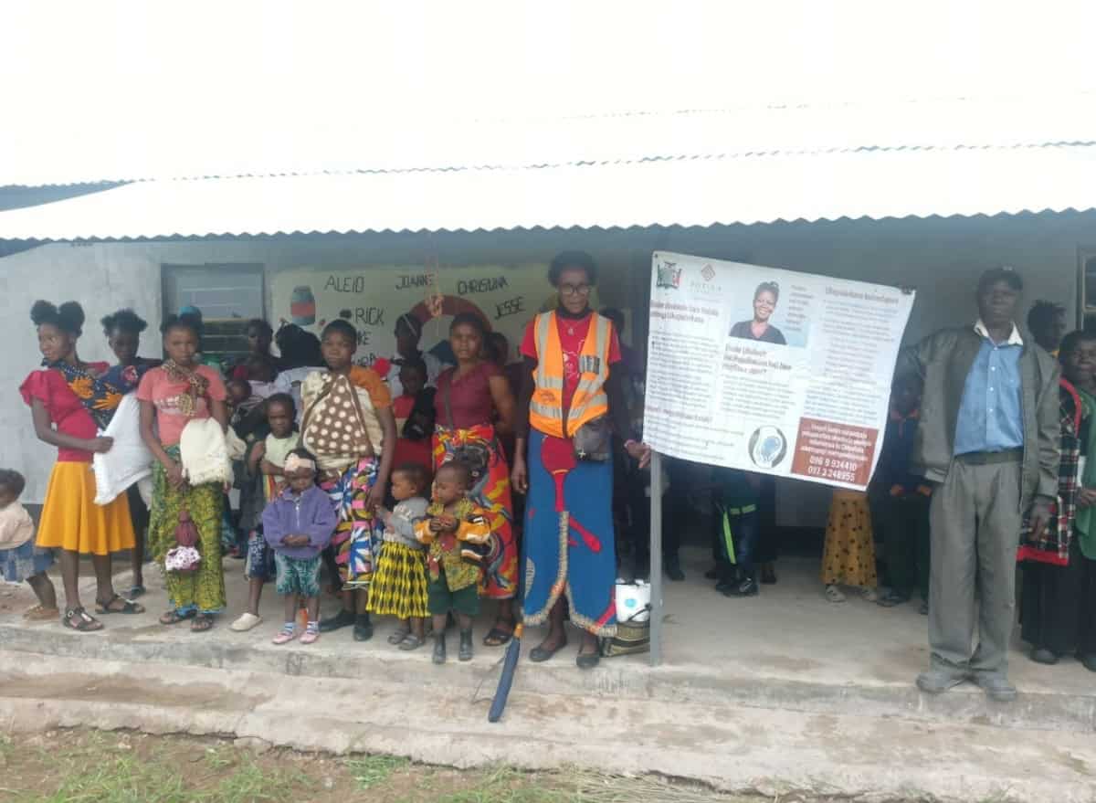 Groep vrijwilligers en lokale bewoners bij Mwishala-project, gebouwd door World Servants.